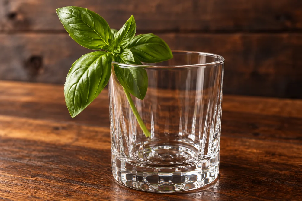 Gin Basil Smash · Garnish on a wooden bar