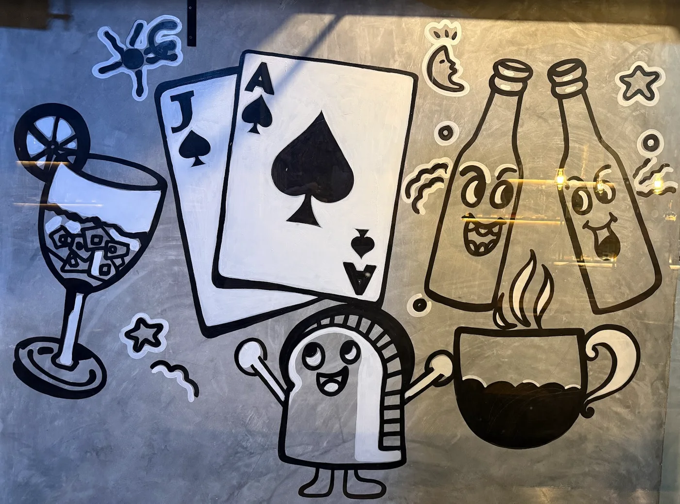 Playing cards and smiling bottles painted on the wall