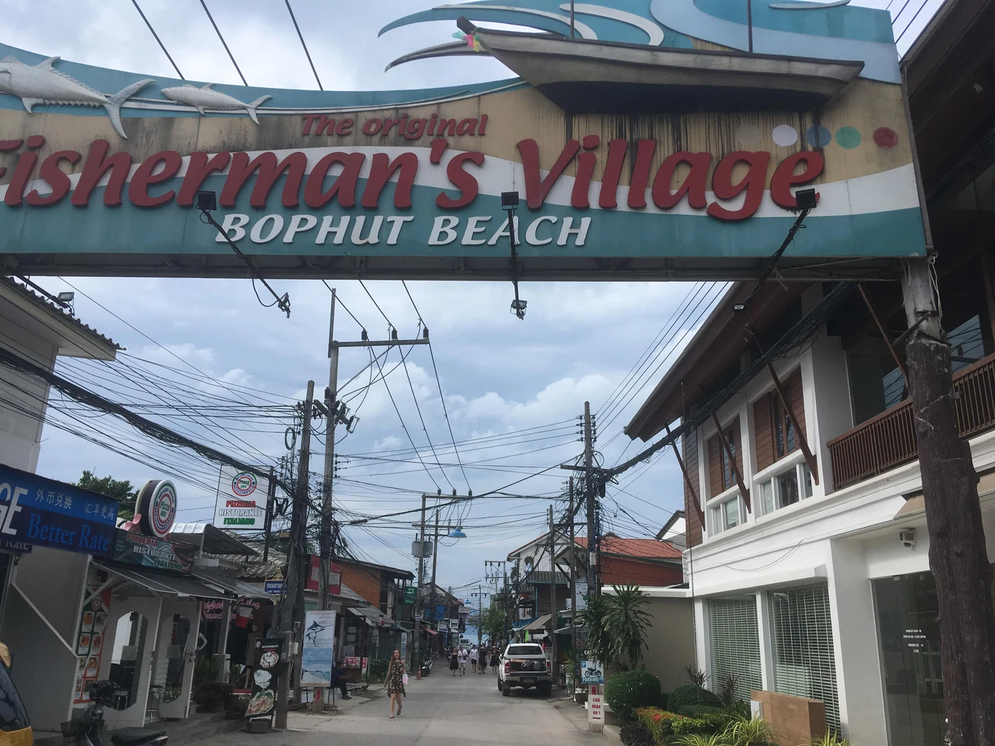 Shophouses and street behind the Fisherman’s Village gateway · 2018