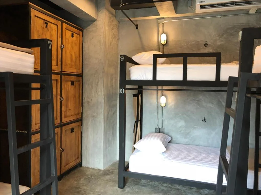 Bunk beds with white bedding and wooden lockers
