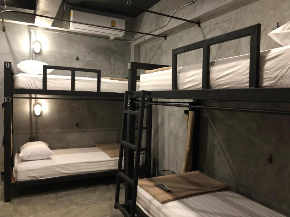 Bunk beds with white bedding and wooden lockers