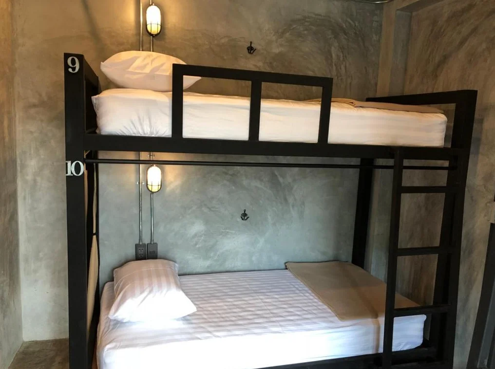Bunk beds with white bedding and wooden lockers